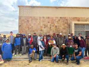 A diverse group of people smiling and posing together in front of the Culli Culli Alto museum