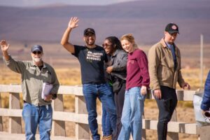 A group of individuals waving and smiling at the camera