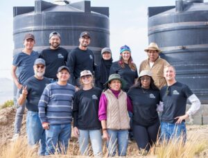 EWB North Texas Professional Chapter group photo in front of 2 water tanks